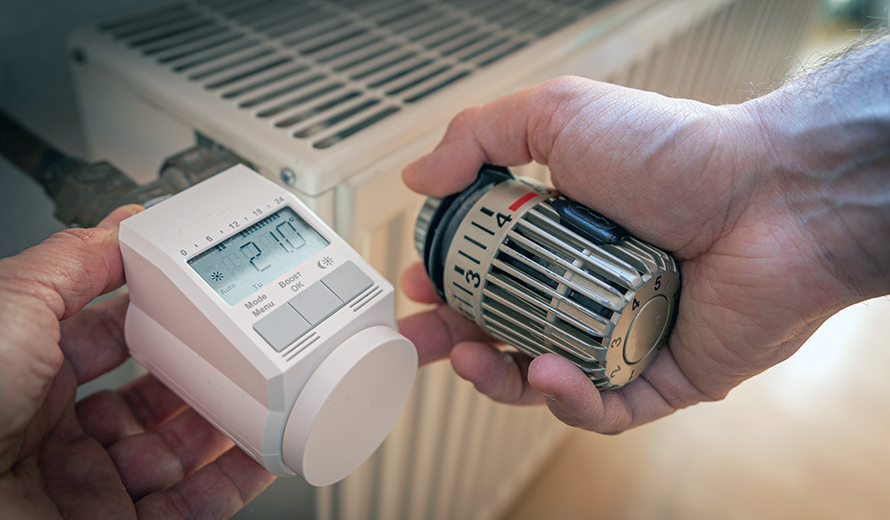 Ein digitales Thermostat an einer Heizung zeigt 18 Grad Celsius an.