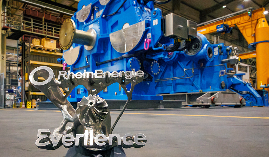 Eine kleine Metallstatue zeigt die Logos von RheinEnergie und Everllence. 