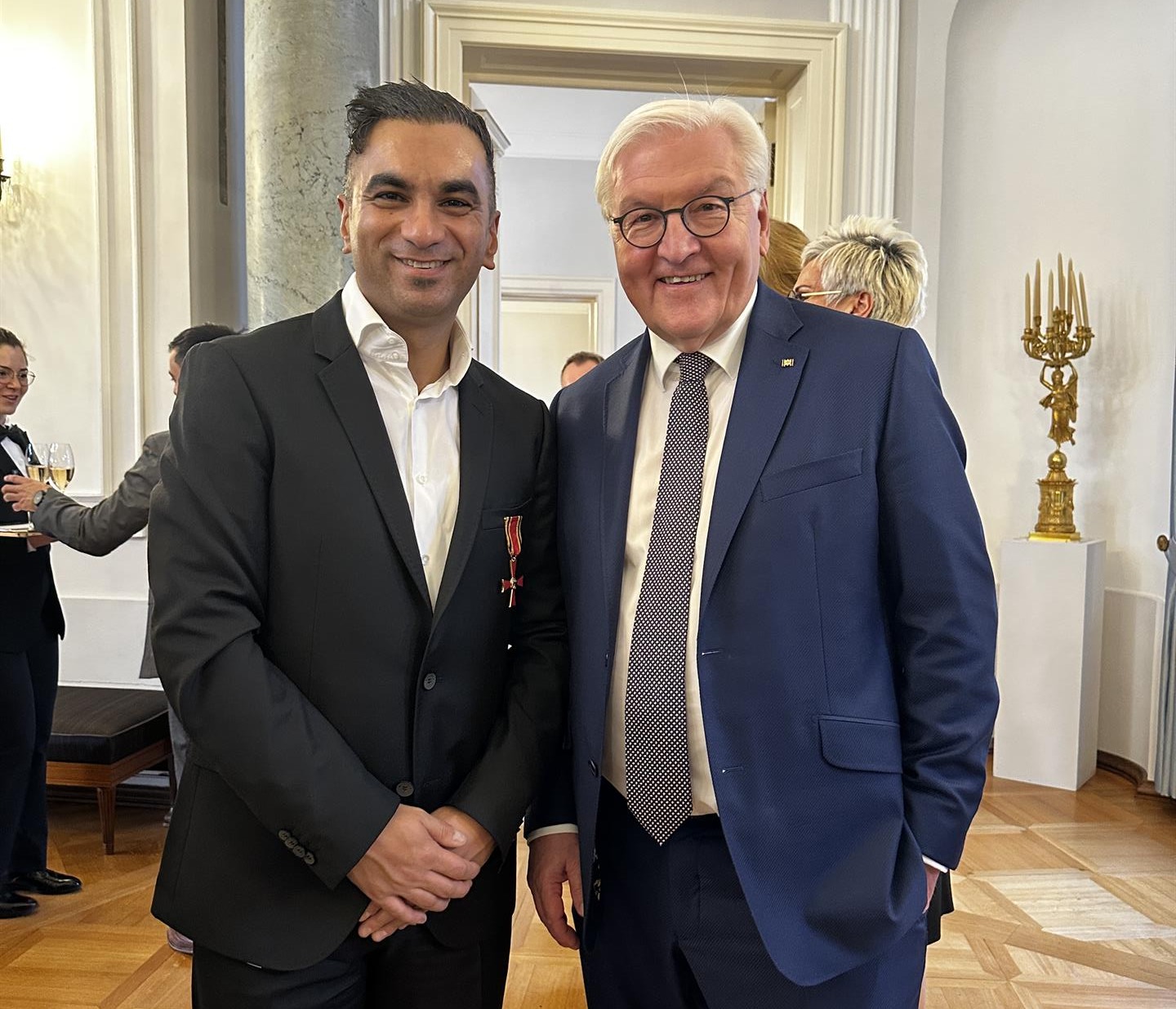 Fatih Türk steht neben Bundespräsident Frank-Walter Steinmeier