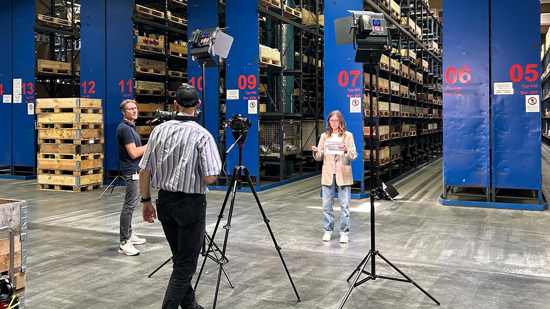 Videodreh in der Lagerhalle der RheinEnergie mit zwei Kameraleuten und Elif, der IT-Spezialistin.