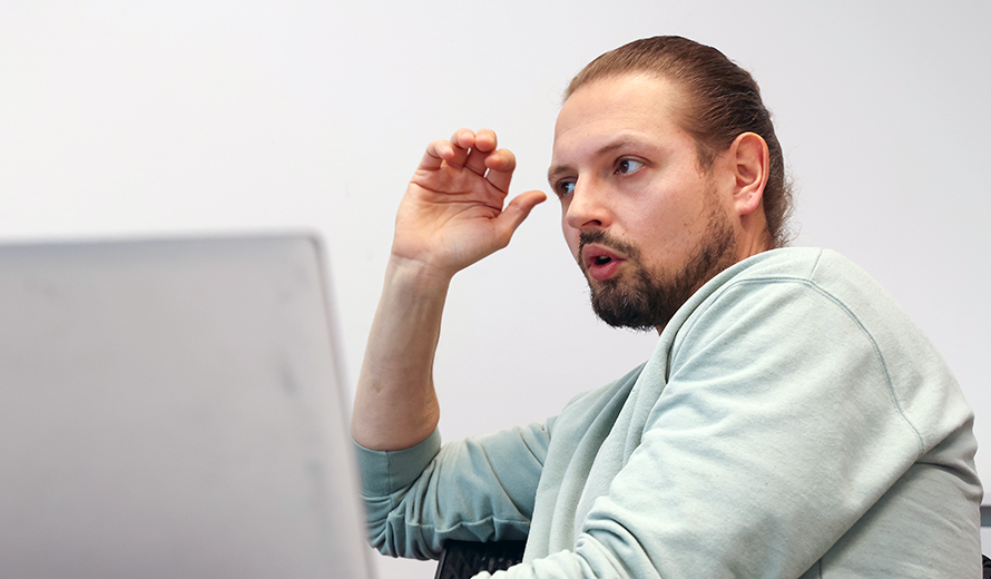 Robert Günzel sitzt sprechend vor einem Laptop.